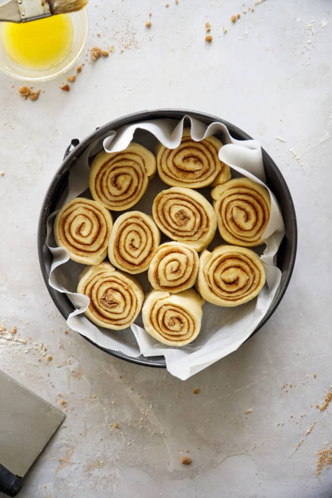 Raw cinnamon buns in a pan.